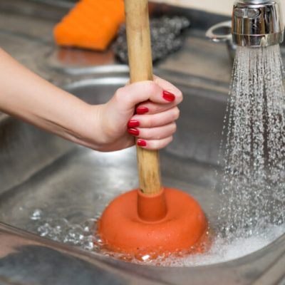 Woman,Cleans,Plunger,With,Clogged,Sink,,Close,Up